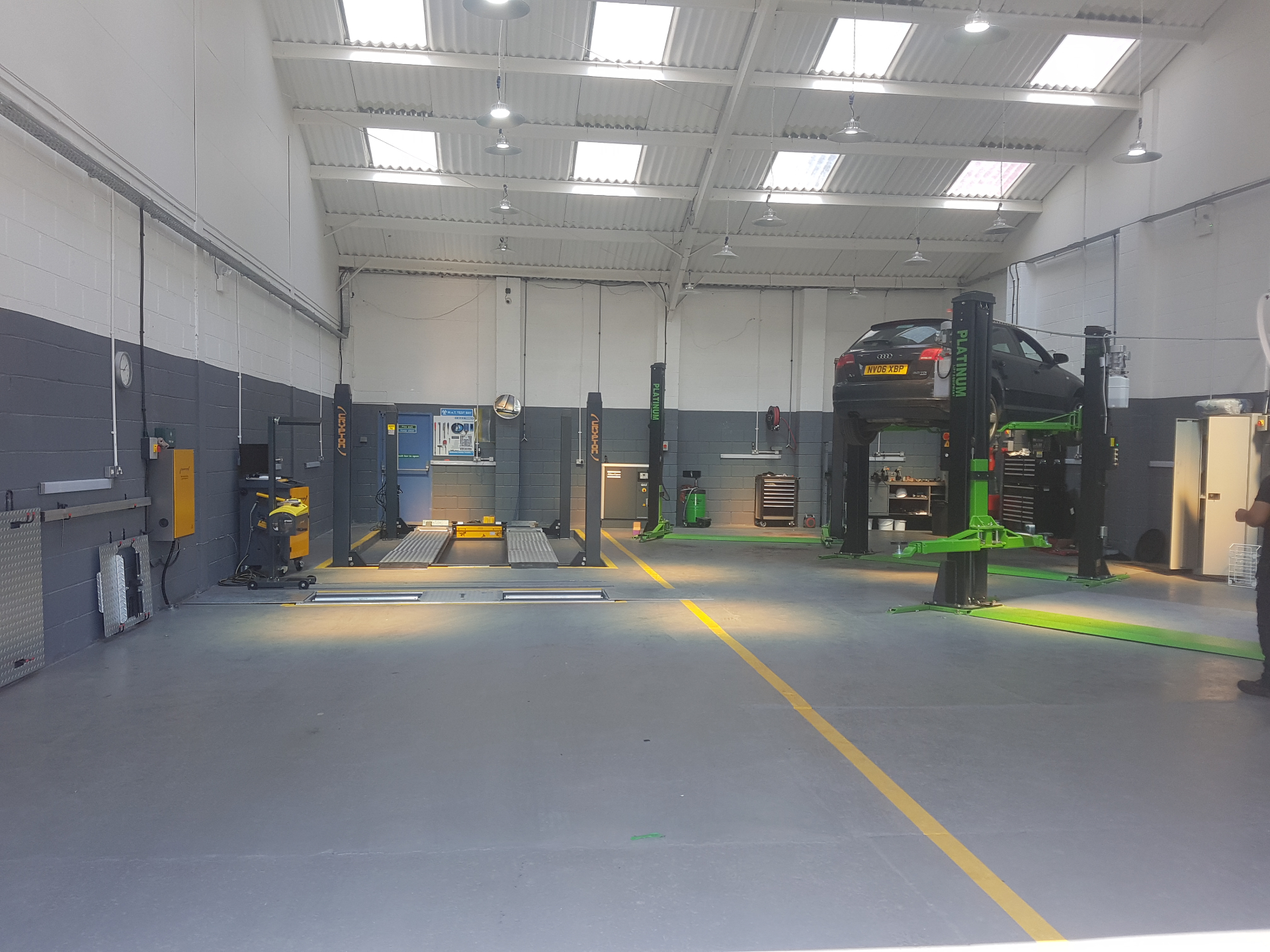 Inside the Autoworks Bradford workshop showing the MOT test bay and a car raised on a two-post ramp