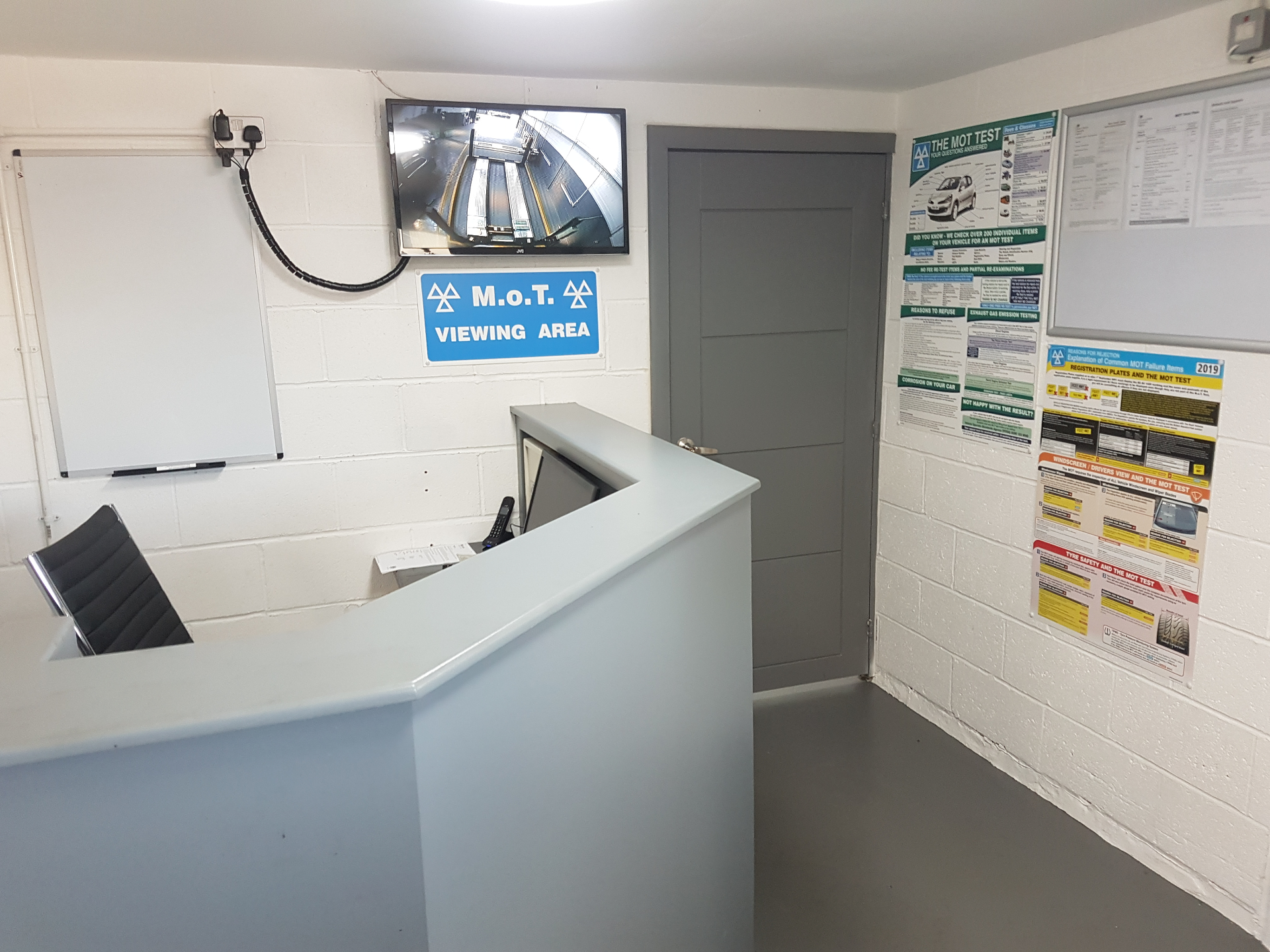Reception desk with the MOT viewing area screen and MOT information posters
